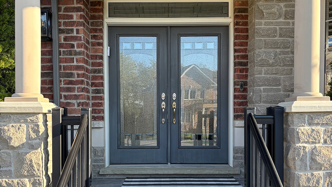 Dark blue double front door with narrow glass panels beneath a transom.