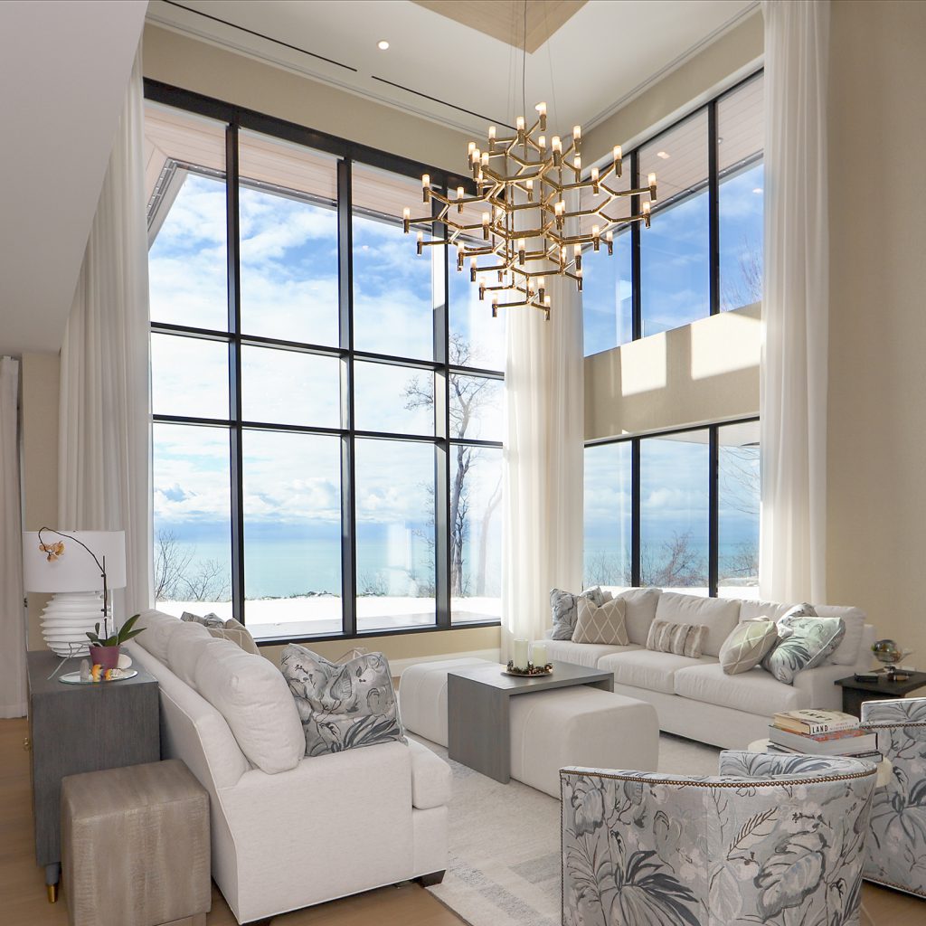 Bright modern living room with expansive black-framed aluminum windows and lake views