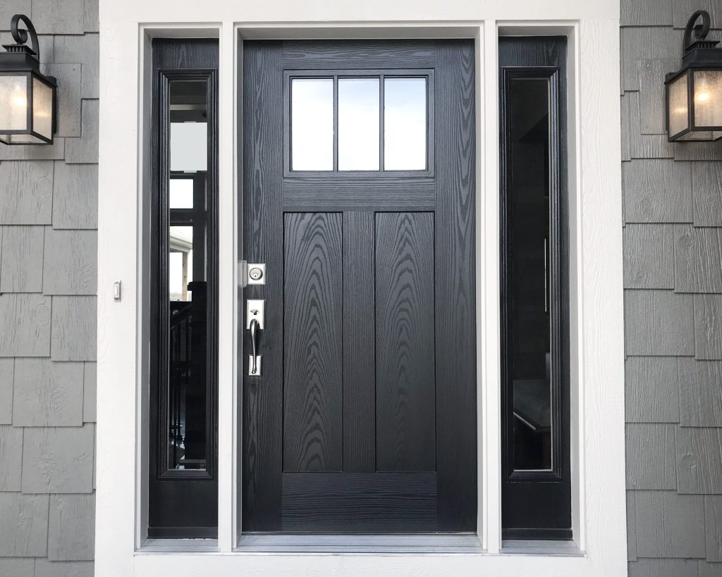 Black woodgrain entry door with three glass panels and narrow sidelights.