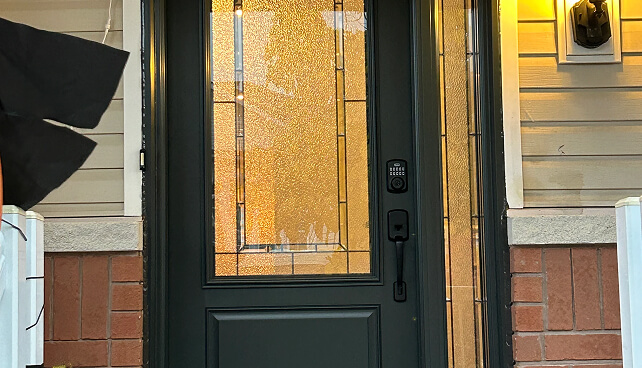 Black front door with textured glass panels and sidelights.