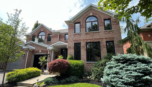 Brick home with custom black windows and a dark front entry door.